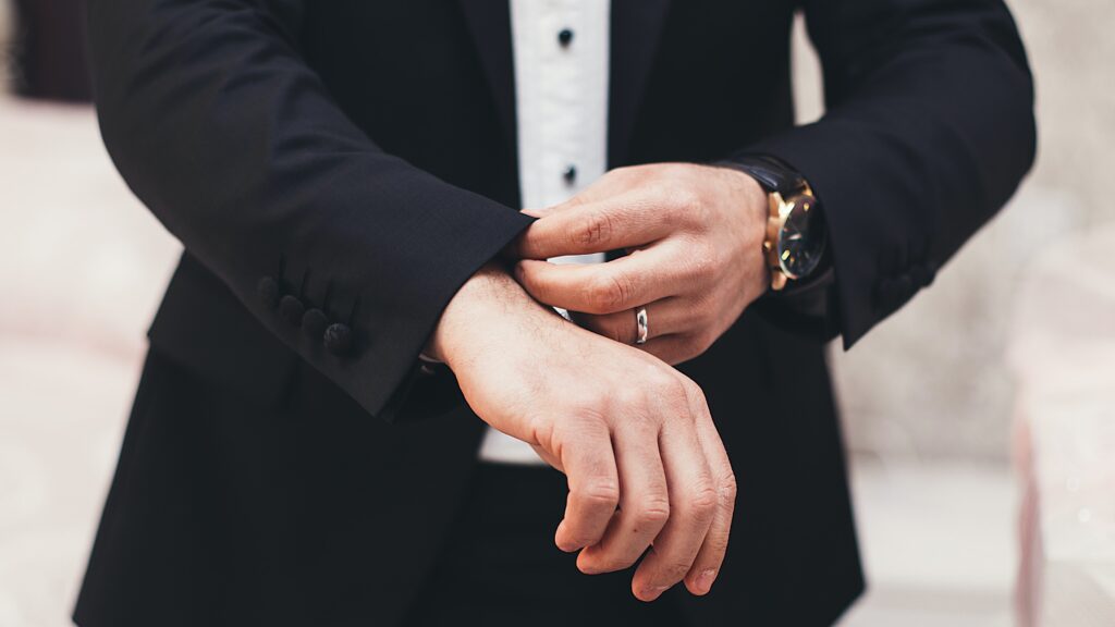 A gentleman showing a ring wearing a suit