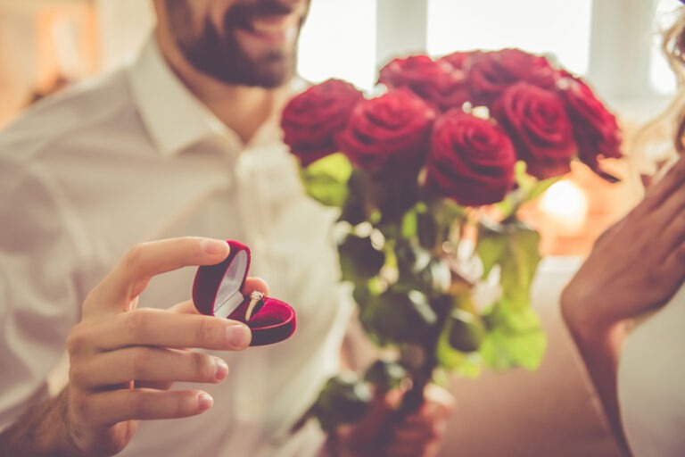 Man holding engagement ring and roses