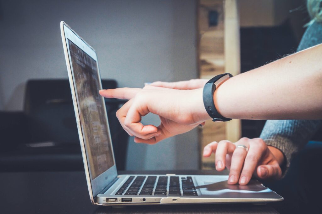 People pointing to a laptop screen