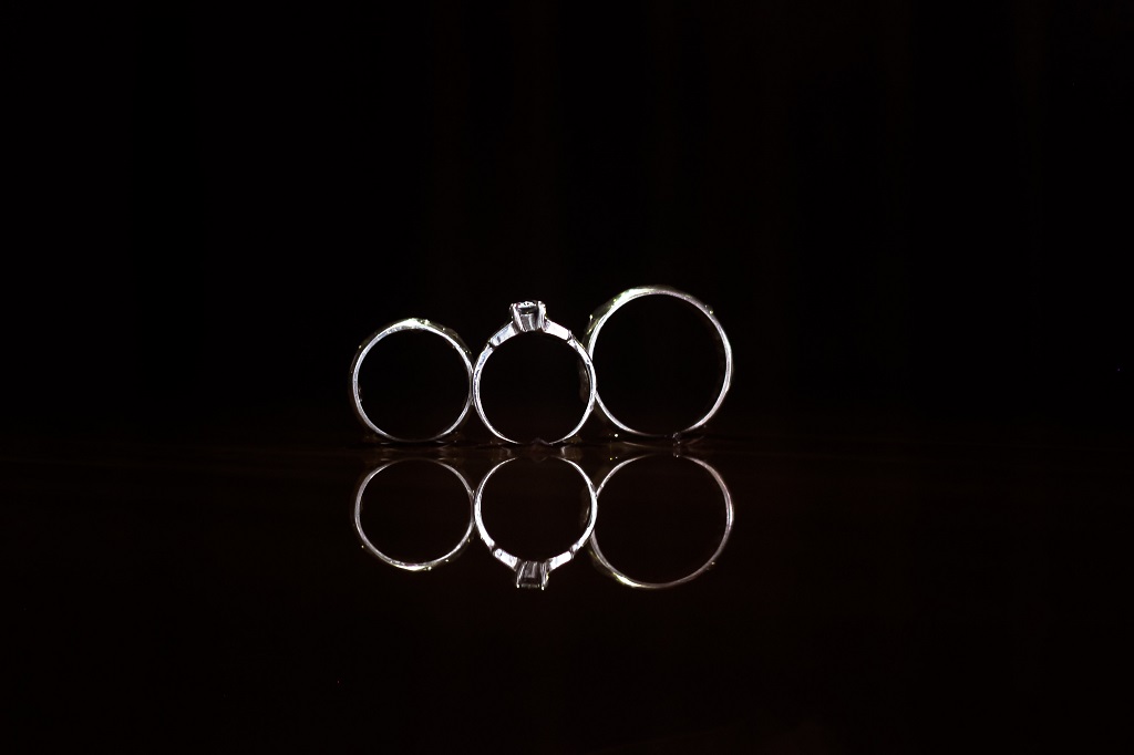 A close shot of thee rings in a black background