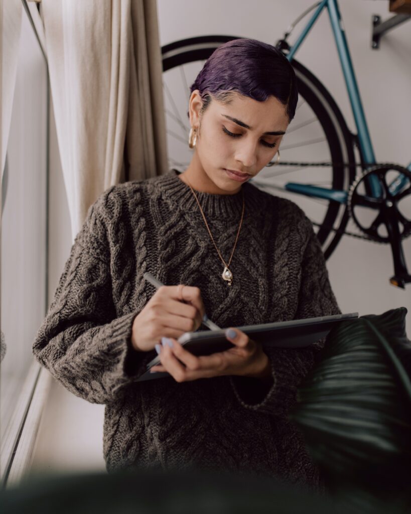 A person in a grey sweater using a tablet to design